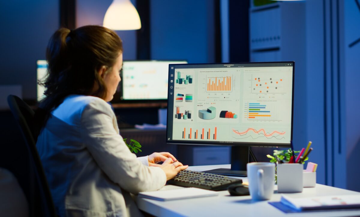 busy-woman-working-night-front-computer-taking-notes-writing-notebook-annual-reports-checking-financial-project-focused-employee-using-technology-network-wireless-doing-overtime-job